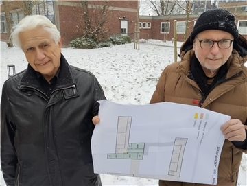 SPD-Kreistagsfraktionsvorsitzender Hans Francksen (links) und der Vorsitzende des Schulausschusses im Kreistag, Uwe Thöle, präsentieren den Plan für einen Anbau am Südtrakt (im Hintergrund) der OBS 1 in Nordenham.