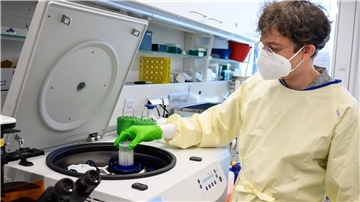 Forscher hebt eine Probe in ein Analysegerät