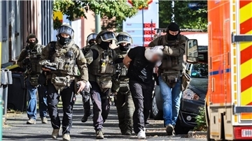 Spezialkräfte der Polizei führen den Verdächtigen ab.