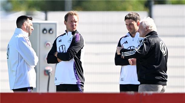 Sportdirektor Rudi Völler (r.) spricht mit Bundestrainer Julian Nagelsmann (2.v.l.) vor dem Training. 