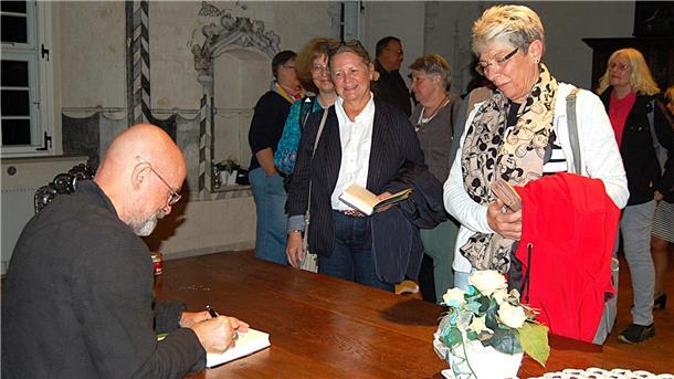 Lesung in der Burg Hagen: Schauspieler und Autor Christian Berkel signiert ein Buch.