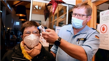 Stabsbootsmann Thomas Liebe misst im Eingangsbereich des Seniorenheims To huus achtern Diek die Körpertemperatur eines Gastes. Insgesamt vier Marinesoldaten tun seit vergangenem Dienstag in Blexen ihren Dienst.