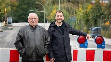 Zwei Männer stehen auf einer Baustelle. 