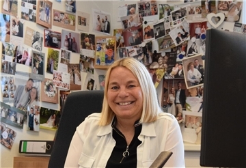 Standesbeamtin Meike Poppe-Friedrich sitzt in ihrem Selsinger Büro vor einer Wand mit Fotos und Karten dankbarer Ehepaare.