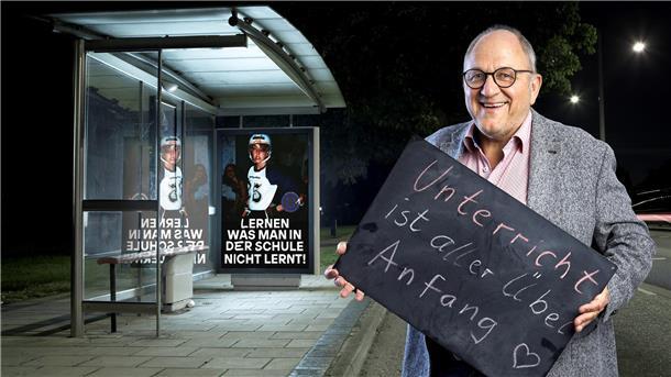 Ein Mann mit einem Schild in der Hand. Es trägt die Aufschrift "Unterricht ist aller Übel Anfang". Als Rektor der Alemannenschule in Wutöschingen hat Stefan Ruppaner Unterricht und Klassenräume abgeschafft.  