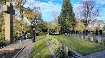Stefan Tönjes vom Volksbund Deutsche Kriegsgräberfürsorge spricht vor dem Hochkreuz auf dem Atenser Friedhof.