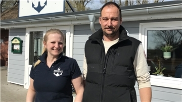 Eine Frau und ein Mann stehen nebeneinander vor ihrem Restaurant