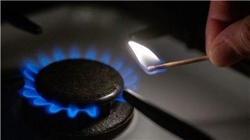 Hohe Strom- und Gaspreise: Was Verbraucher jetzt tun können Eine Gasflamme wird auf einem Küchenherd mit einem Streichholz entzündet.