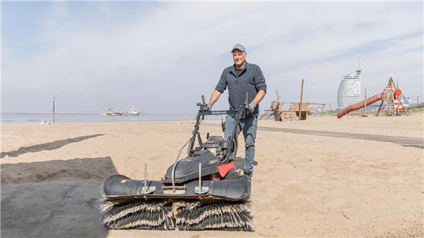 Weserstrandbad Bremerhaven: Was Besucher wissen müssen Mann mit Kehrmaschine: Strandmeister Olaf Ballhoff bringt den Sand und Wege auf Vordermann – für einen sauberen Saisonstart.