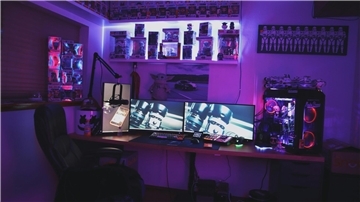 Schreibtisch mit PC und Bildschirmen.
