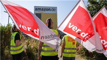 Streikende stehen mit Fahnen von Verdi vor einem Verteilzentrum des Online-Händlers Amazon in Leipzig. (Archivbild)
