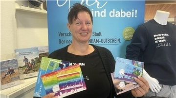Svenja Faehse präsentiert die neuen Nordenham-Gutscheine, die jetzt auch digital zu haben sind.
