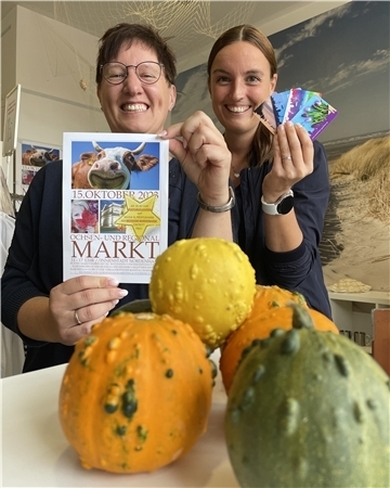 Svenja Faehse von NMT präsentiert den Flyer zum Ochsenmarkt, ihre Kollegin Sandra Jankowsky die neuen Nordenham-Gutscheinkarten.