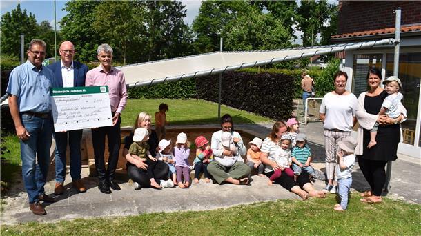 Symbolische Scheckübergabe im Garten der Krippe des Vereins Lebenshilfe in Brake mit Vertretern des Lions-Club Brake