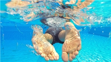 Bremerhavens Bäder: Diebe und Sexualstraftäter trüben den Badespaß Füße eines Schwimmers im Wasser.