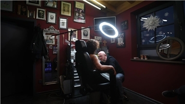 Tattoo-Künstler Andy Engel (r) tätowiert der Brustkrebspatientin Anja D. eine Brustwarze.