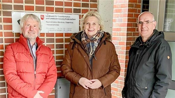 Zwei Männer und eine Frau stehen vor dem Eingang des Katasteramtes Brake.