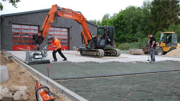 Teamwork für die Auffahrt zum neuen Feuerwehrhaus in Drangstedt (von links): Frank Döscher, Baggerführer, und Polier Egon Küsel sowie Marcel Gerdes beim pflastern.