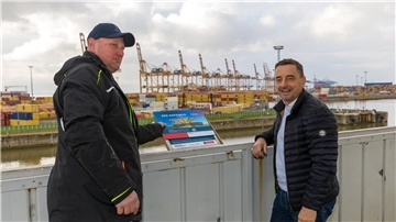 Sven Bade und Michael Gerber, der Geschäftsführer der Erlebnis Bremerhaven, haben die neuen Info-Tafeln auf dem Aussichtsturm angebracht.