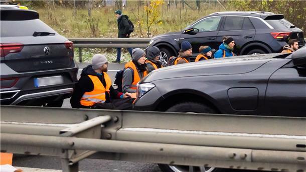 Teilnehmer eines Klimaprotests blockieren auf der A113 kurz vor der Ausfahrt zum Flughafen Berlin Brandenburg (BER) „Willy Brandt“ den Verkehr.