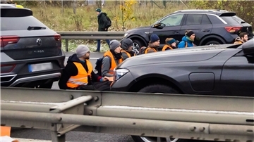 Teilnehmer eines Klimaprotests blockieren auf der A113 kurz vor der Ausfahrt zum Flughafen Berlin Brandenburg (BER) „Willy Brandt“ den Verkehr.