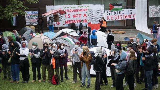 Teilnehmerinnen und Teilnehmer stehen während einer propalästinensischen Demonstration der Gruppe „Student Coalition Berlin“ auf dem Theaterhof der Freien Universität Berlin.