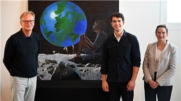 Gruppenfoto mit zwei Herren, einer Frau und einem Gemälde, das sich zwischen den beiden Herren befindet. „The End of Nowhere“ von Paris Giachoustidis (Mitte) ist das erste Kunstwerk der Sonderausstellung „Verlockung Weltall. Auswandern auf Mars, Mond und Venus?“ ist im Deutschen Auswandererhaus. Das Foto zeigt zudem Jörg Schulz und Dr. Simone Blaschka.