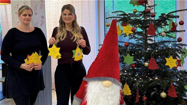 Zwei Frauen neben einem Weihnachtsbaum.