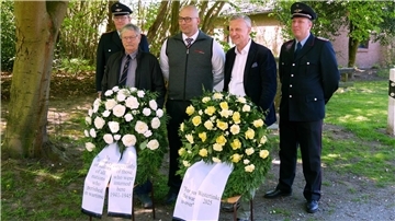 Thomas Gabe, Knut Ehlert und Michael Ahrens (von links) sowie die Gemeindebrandmeister gedachten der ehemaligen Kriegsgefangenen und legten Kränze an der Gedenktafel des Lagers MILAG nieder.