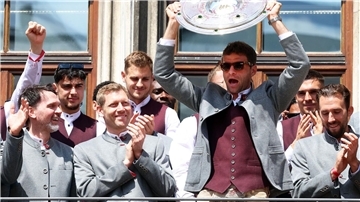 Thomas Müller jubelt zum Bayern-Abschied noch mal mit der Meisterschale auf dem Münchner Rathausbalkon. 