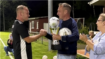 Thorsten Schwarz vom TSV Iselersheim (rechts) überreicht Mannschaftskapitän Christoph Klee vom Siegerteam den Pokal.