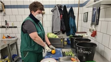 Tierpflegerin Annika Diekmann bereitet im Zoo am Meer das Futter für die Schimpansen vor. Manchmal versteckt sie auch Rosinen in Fahrradreifen, damit die Tiere eine Beschäftigung haben. Schon in der Futterküche arbeitet sie mit FFP2-Maske und Handschuhen.