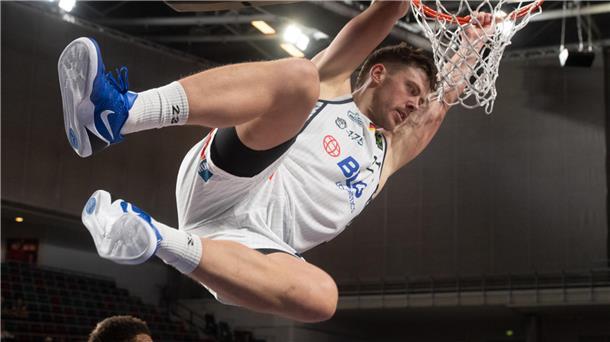 Eisbären feiern den dritten Sieg im dritten Heimspiel Ein Basketballer hängt sich nach einem Dunking an den Korb. Es ist Till Isemann von den Eisbären,