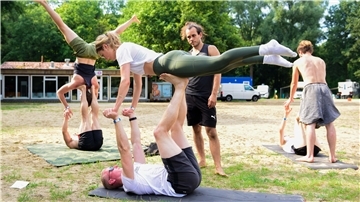 Tobias und Caro lassen sich beim „Acro Yoga“ von Kursleiter Yannick einige Kniffe zeigen.
