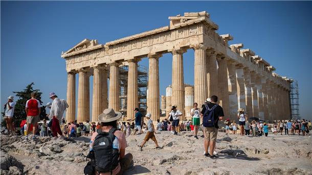 Mehrheit europäischer Städte mit Klimagefahren konfrontiert Touristen an einem heißen Tag bei ihrem Besuch des Parthenon-Tempels auf dem Akropolis-Hügel in Athen.