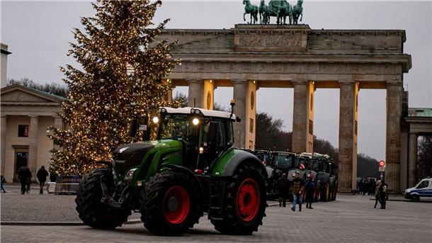 Bauern mit Wut und Traktoren gegen Aus für Agrardiesel Traktor vor einem Weihnachtsbaum am Brandenburger Tor. Nach Verbandsangaben würden der Landwirtschaftsbranche mit den geplanten Streichungen fast eine Milliarde Euro entzogen.
