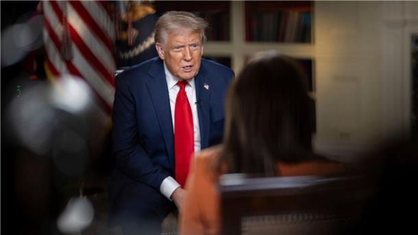 Donald Trump sitzt auf einem Stuhl und wird von einer Journalistin interviewt. 