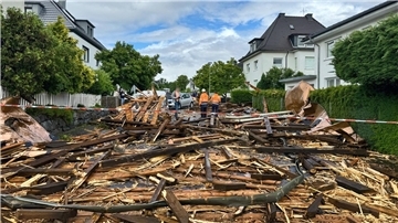 Trümmer des Kirchturmdaches liegen auf der Straße: Der Dachstuhl wurde nun völlig zerstört.
