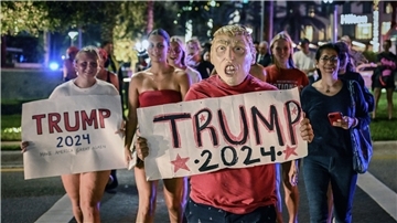 Trump-Anhänger mit Plakaten mit der Aufschrift " Trump 2024" feiern einen möglichen Sieg von Donald Trump am 5. November 2024 in Palm Beach (USA).