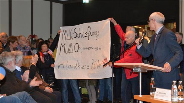 Tumultartige Zustände herrschten im Zevener Rathaussaal Mitte März 2018. Mehr als 500 Besucher bekundeten ihren Protest gegen die angekündigte Schließung des Zevener Krankenhauses. Begleitet von tosendem Applaus trug Dr. Wolfgang Trescher gemeinsam mit seiner Frau Ilonka Timm-Trescher ein Transparent in den Saal. Landrat Hermann Luttmann (rechts) ließ sich davon nicht beeindrucken. Das MLK ist längst Geschichte. Jetzt ist es auch der Förderverein.