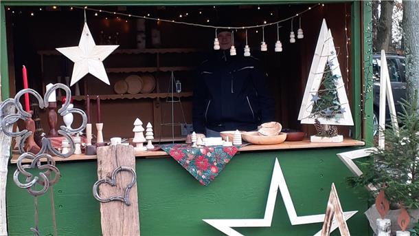 Weihnachtliche Dekorationen liegen in einem Verkaufsbüdchen. 