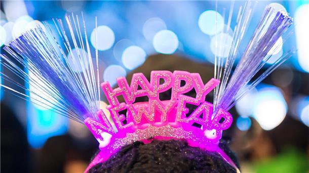 Hier kann ins neue Jahr 2023 gefeiert werden Eine Frau trägt ein Haarband mit der Aufschrift: Happy New Year".