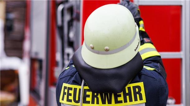 Ein Feuerwehrmann mit Helm von hinten