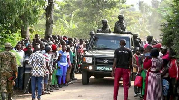 42 Schüler bei Angriff auf Schule in Uganda getötet Ugandische Sicherheitskräfte fahren an einer Menschenmenge vorbei, die sich nach dem Angriff vor der Schule in Mpondwe versammelt hat (Videostandbild).