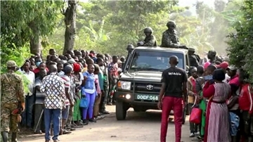 Ugandische Sicherheitskräfte fahren an einer Menschenmenge vorbei, die sich nach dem Angriff vor der Schule in Mpondwe versammelt hat (Videostandbild).