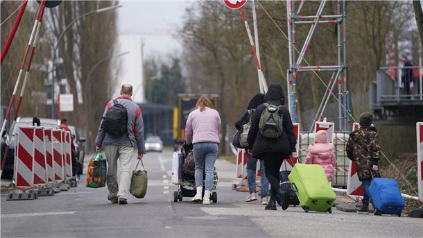 Ukrainische Flüchtlinge verlassen mit ihrem Gepäck die Flüchtlingsunterkunft in Hamburg.