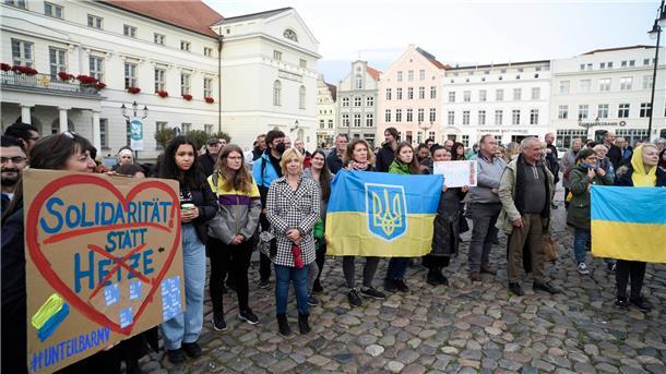 Ermittlungen laufen nach Brand in Flüchtlingsunterkunft Ukrainische Frauen und weitere Teilnehmer stehen bei einer Mahnwache auf dem Wismarer Marktplatz.