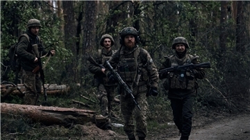 Ukrainische Soldaten gehen in der Nähe der russischen Stellungen in der Region Luhansk durch den Wald.