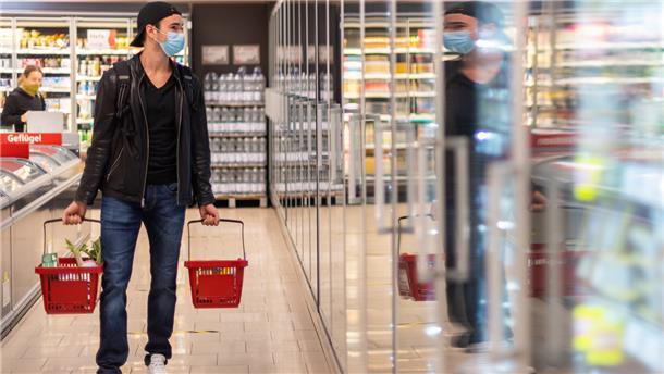 Ein Kunde geht in einem Supermarkt einkaufen.