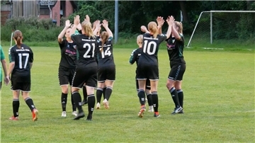 Frauen in schwarzen Trikots jubeln
